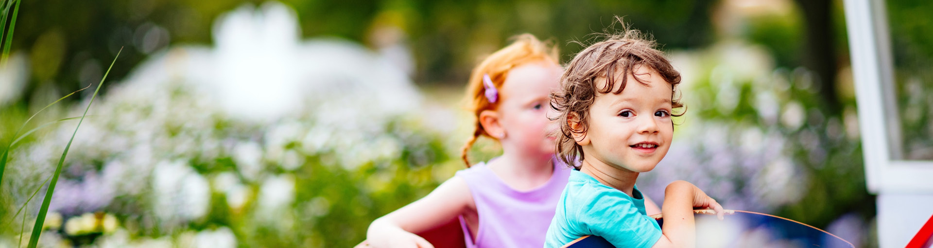 Kinder sitzen im Bollerwagen